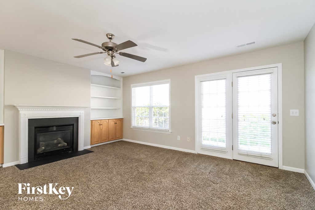 a living room with a fireplace and a ceiling fan