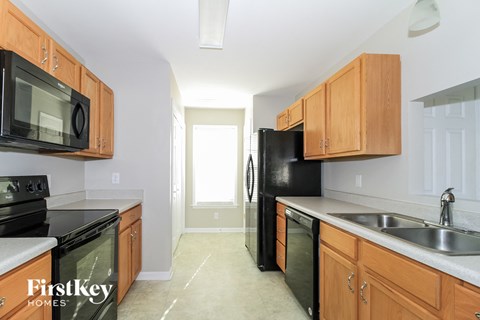 a kitchen with wood cabinets and black appliances and a black refrigerator