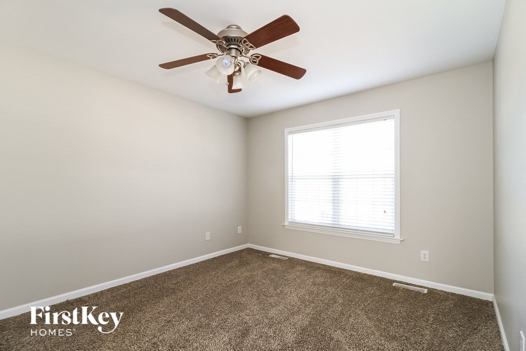 a bedroom with a ceiling fan and a window
