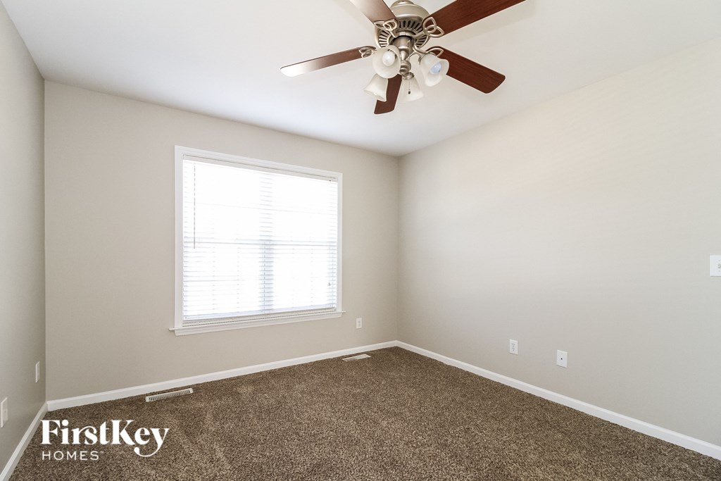 a bedroom with a ceiling fan and a window