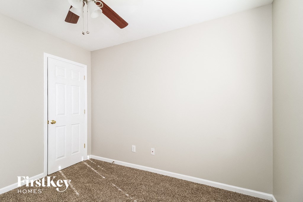 a bedroom with a carpeted floor and a white door