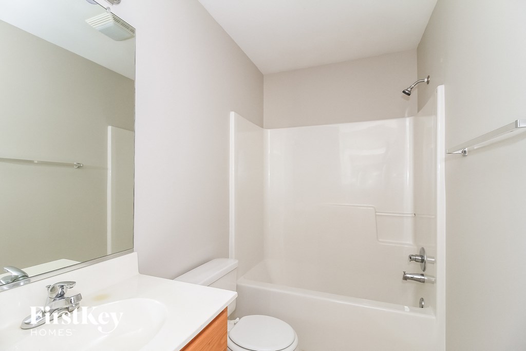 a white bathroom with a shower and a sink and a toilet
