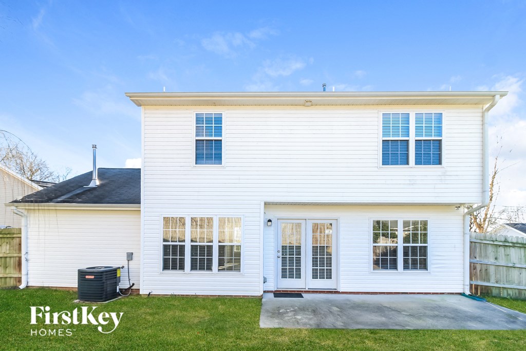 the front of a white house with a garage and a driveway