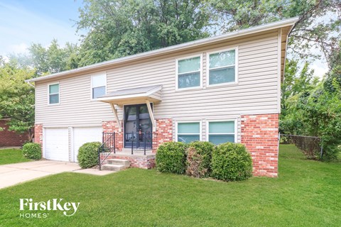 A house with a garage and a brick wall.