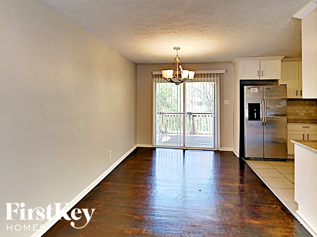 an empty kitchen with stainless steel appliances and hard wood flooring