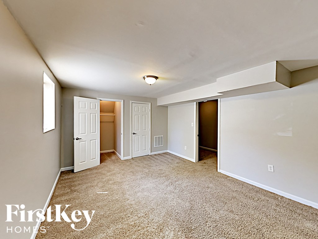 an empty living room with white walls and a carpeted floor
