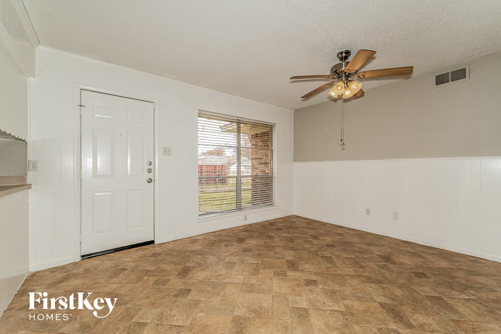 the living room of an empty house with a ceiling fan