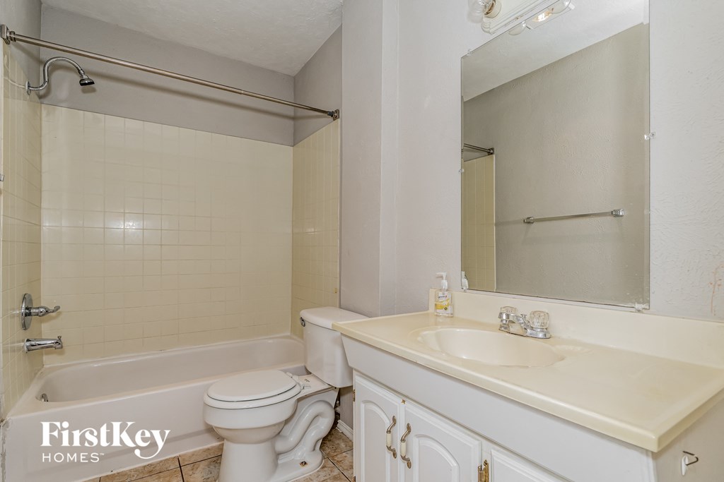 a bathroom with a sink toilet and tub and a mirror