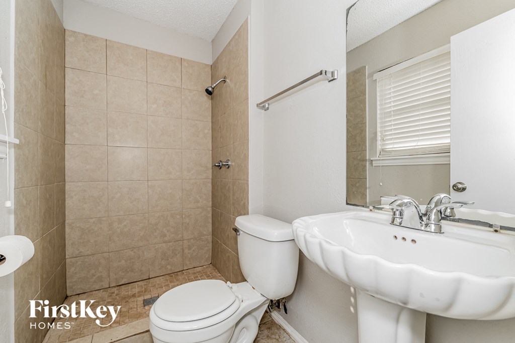 a bathroom with a toilet and a sink and a mirror