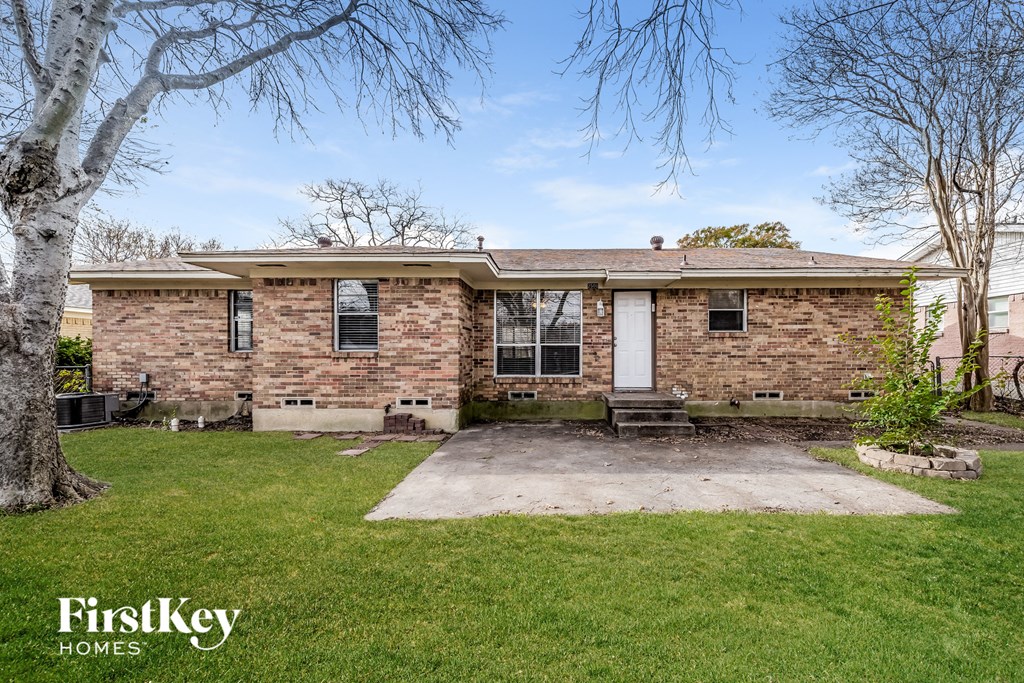 a small brick house with a yard and grass