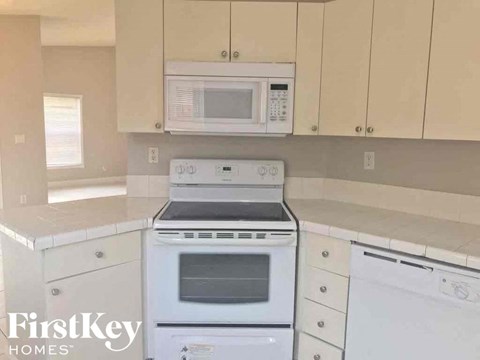 A white oven and microwave are on a kitchen counter.