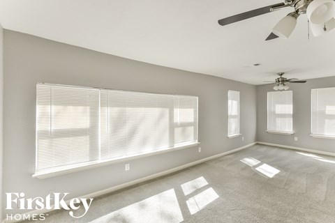 a living room with a large window and a ceiling fan