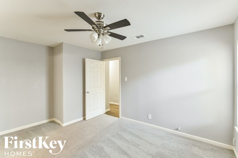 the master bedroom has a ceiling fan and a carpeted floor