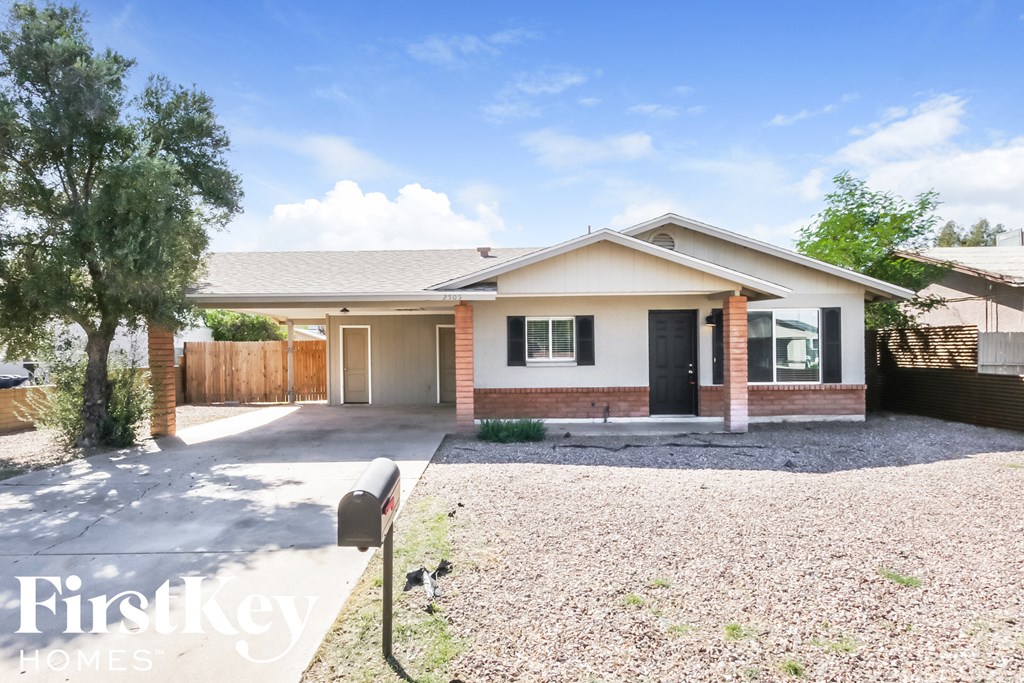 a small brick house with a driveway and a porch