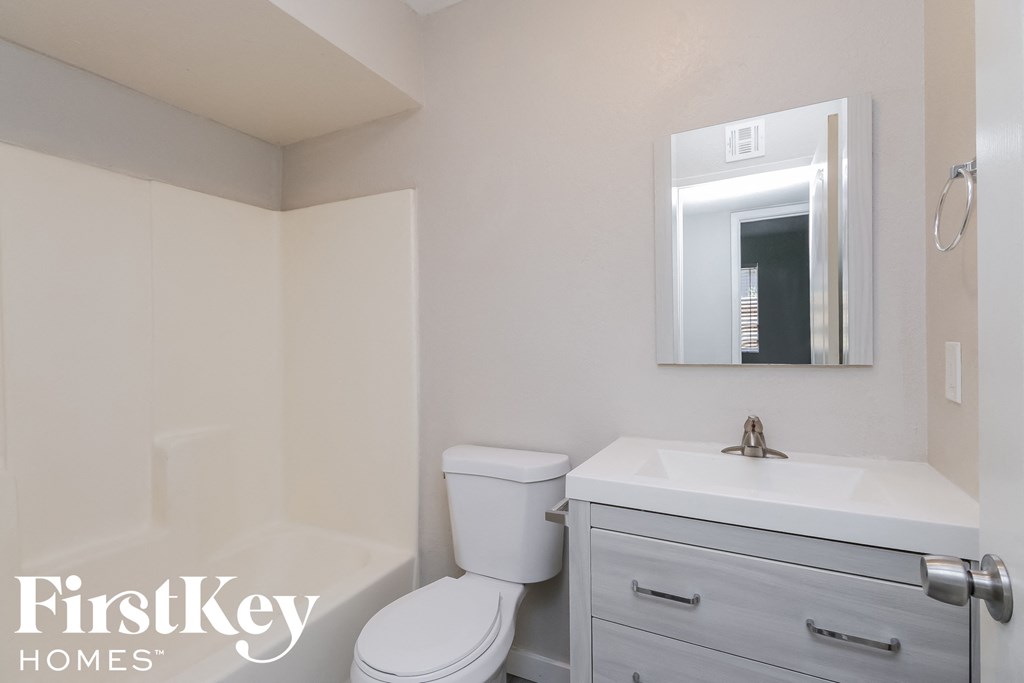 a bathroom with a toilet sink and mirror and a sink and a toilet