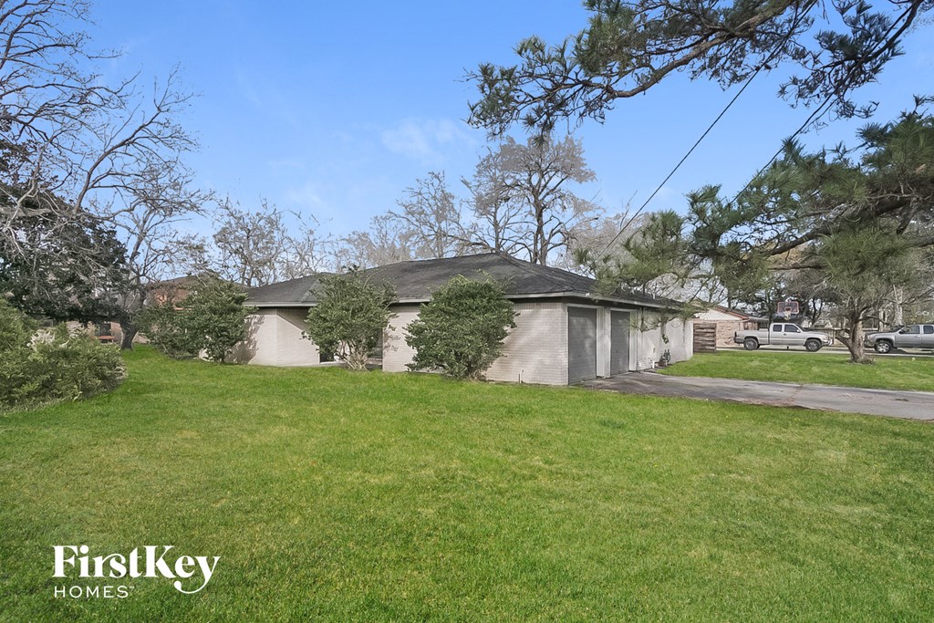 a house with a lawn and trees in front of it