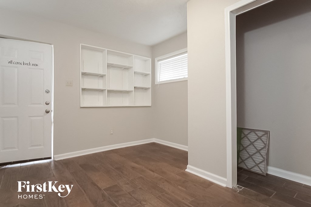 a room with a closet and a white door and a wooden floor