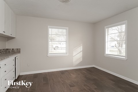a kitchen with white cabinets and a hard wood floor