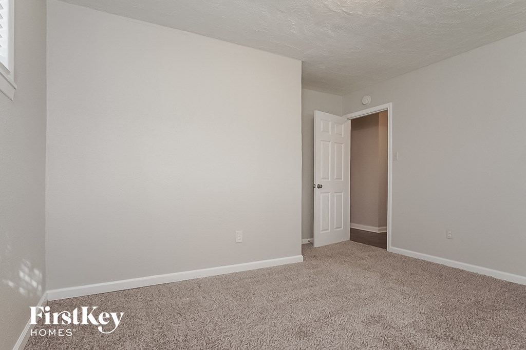 a bedroom with a door to a closet and a carpeted floor