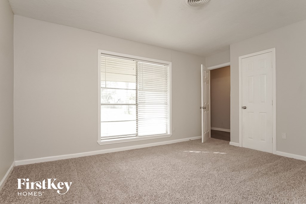 a bedroom with a large window and a white door