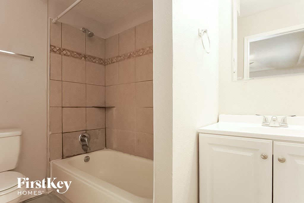 a bathroom with a tub and a sink and a toilet