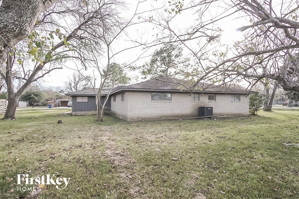 a small white house in a field with trees