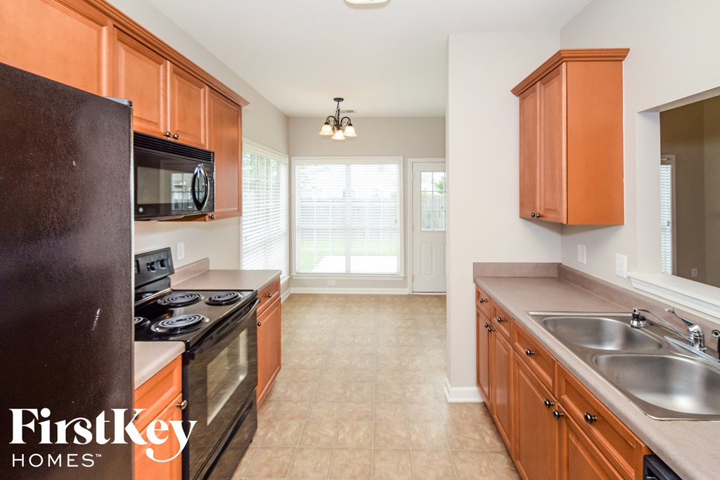 a kitchen with wood cabinets and black appliances and a sink