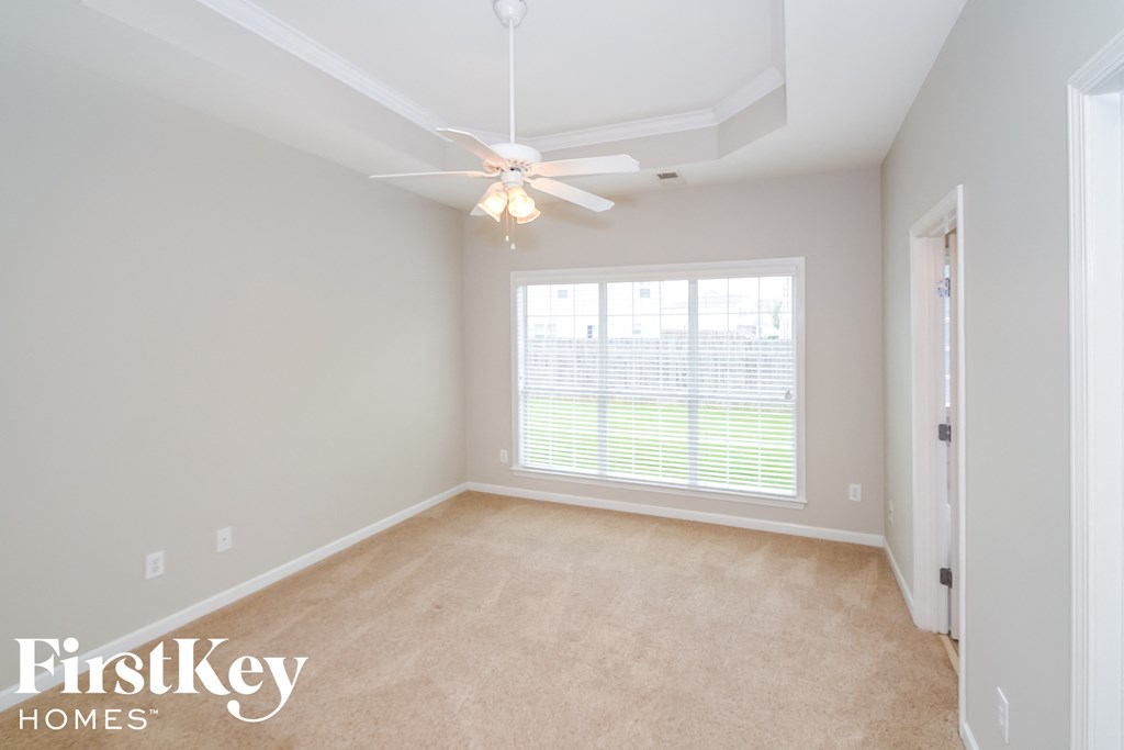 a bedroom with a ceiling fan and a large window