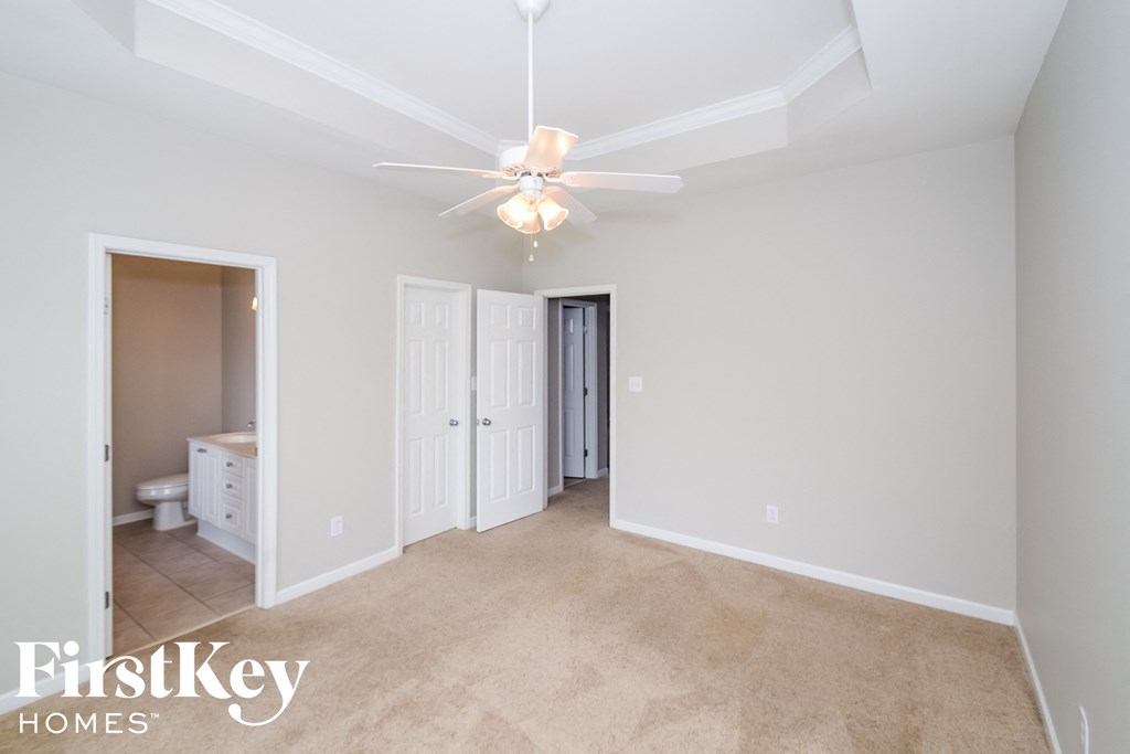 a master bedroom with a ceiling fan and a bathroom