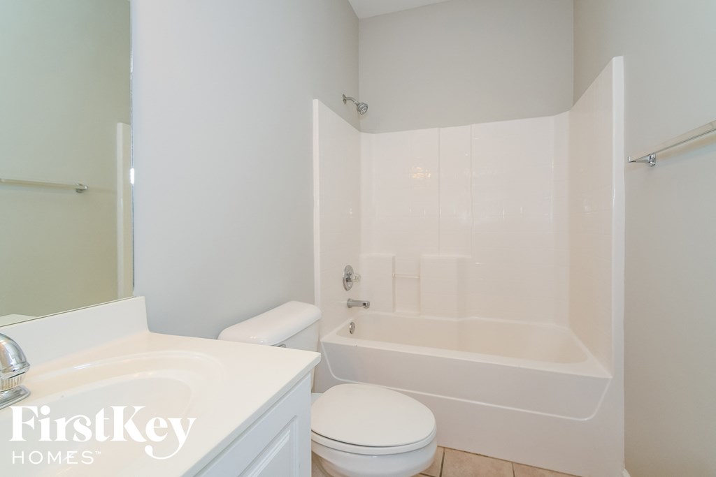 a white bathroom with a tub and a sink and a toilet