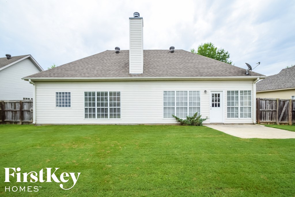 the front of a white house with a lawn and a driveway