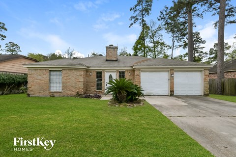 a brick house with white garage doors and a lawn