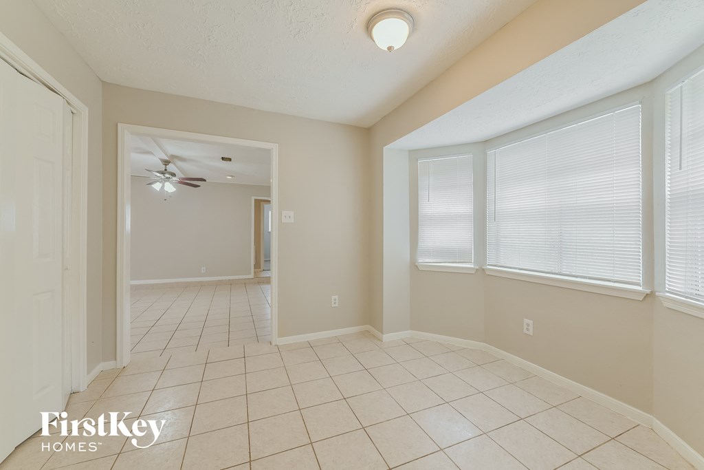 a living room with a ceiling fan and a tiled floor