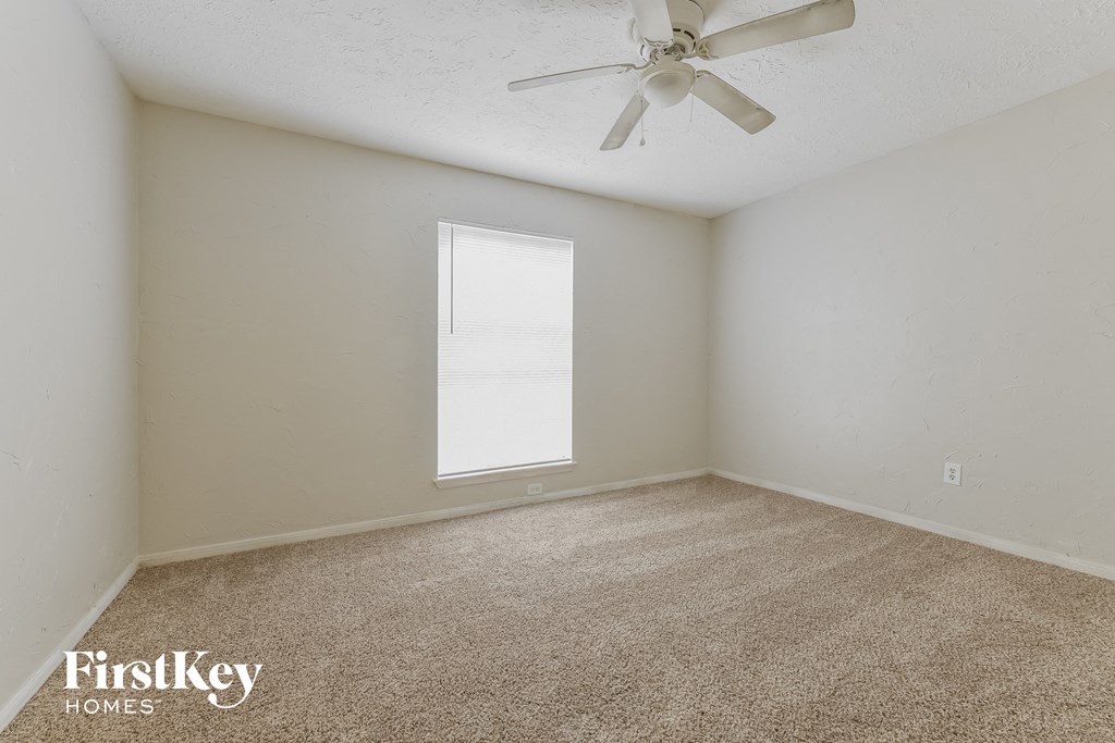 a bedroom with carpet and a ceiling fan
