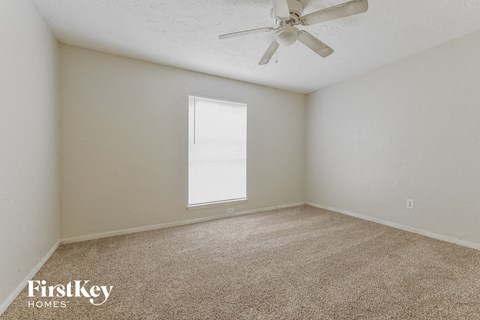 a bedroom with carpet and a ceiling fan