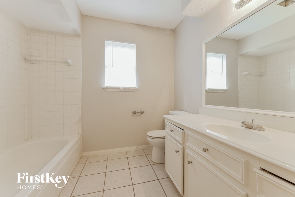 a white bathroom with a sink and a toilet and a tub