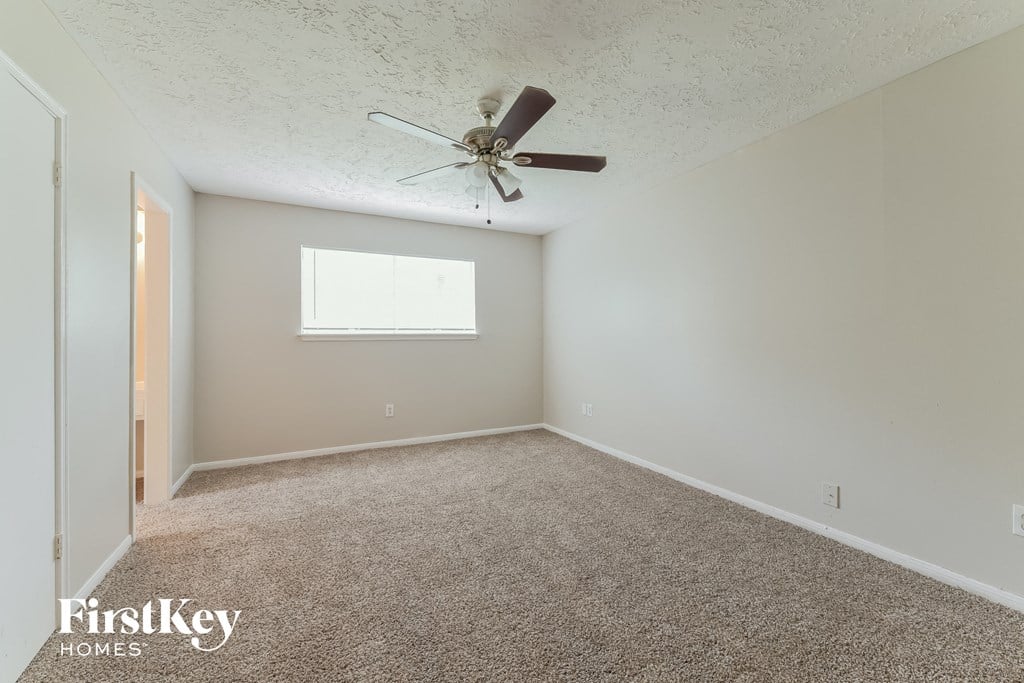 a bedroom with carpet and a ceiling fan