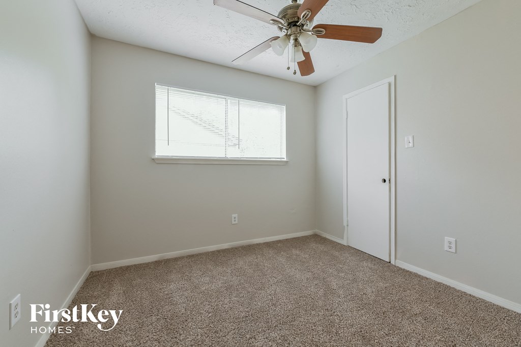 a bedroom with a ceiling fan and a window