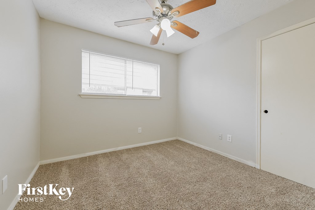 a bedroom with a ceiling fan and a window