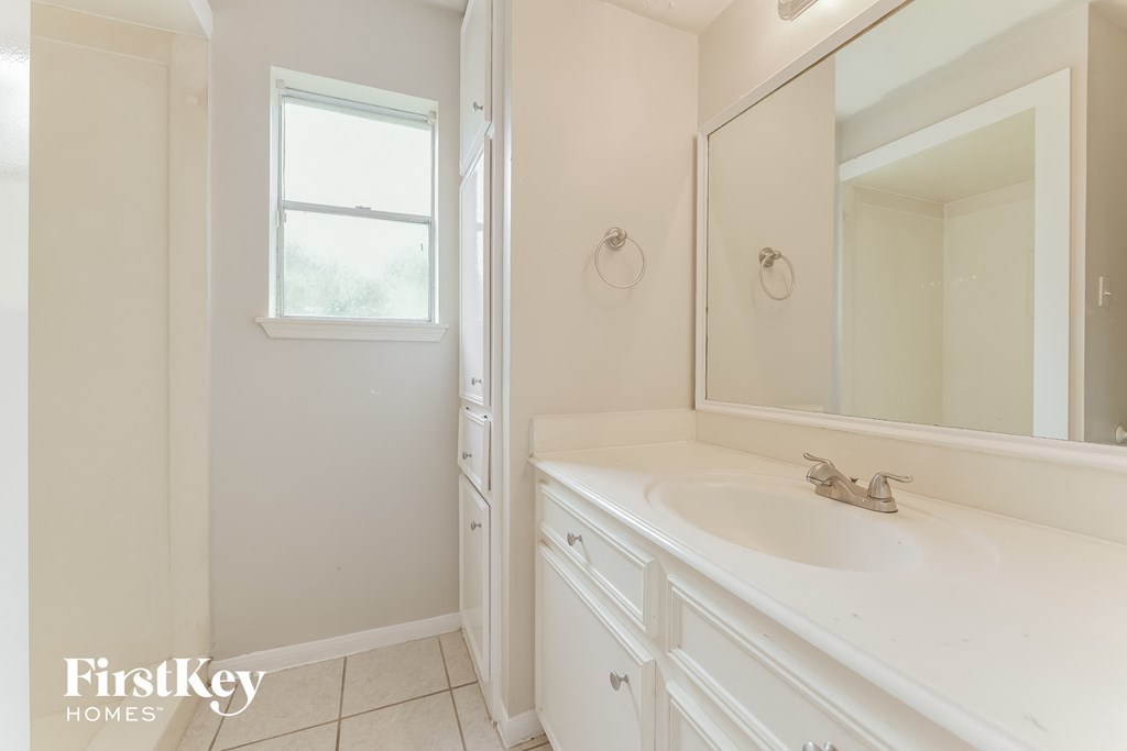 an empty bathroom with a sink and a mirror