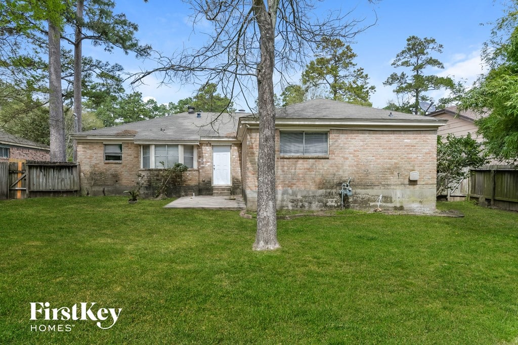 a brick house with a yard and a tree