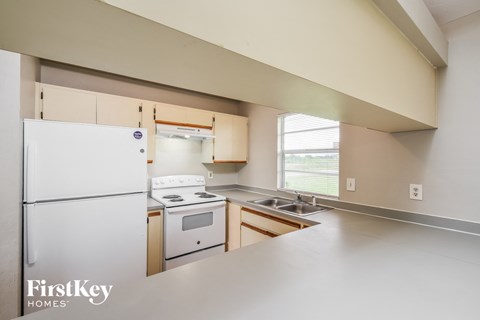 A kitchen with a white refrigerator and a stove top oven.