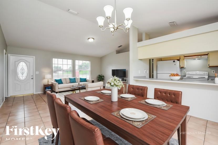 A dining room with a wooden table set for four.