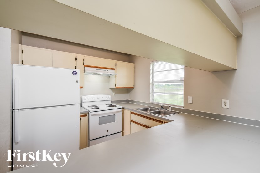 A kitchen with a white refrigerator and a stove top oven.
