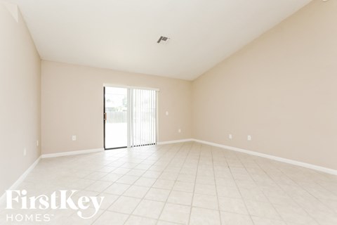 A spacious empty room with a sliding glass door.