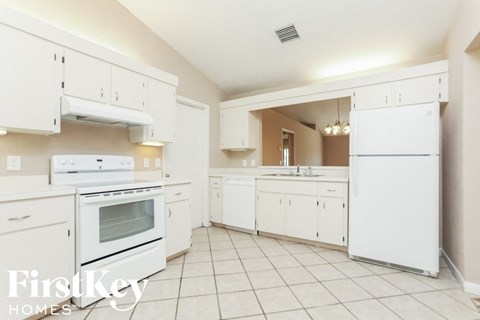 A kitchen with white appliances and cabinets.