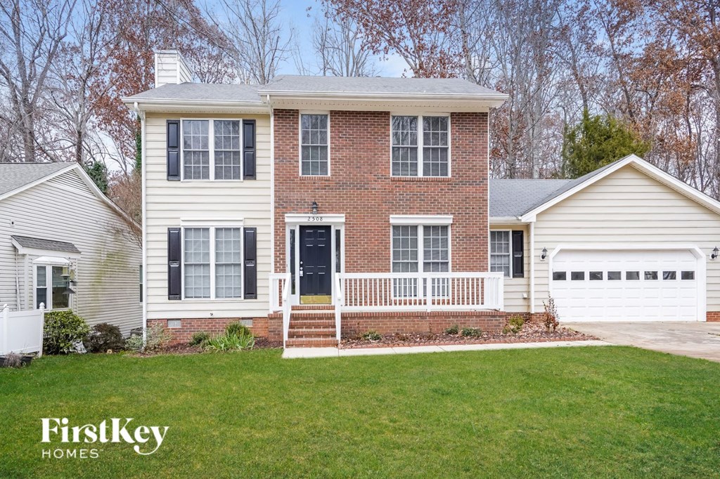 A house with a white garage door and a brick wall.