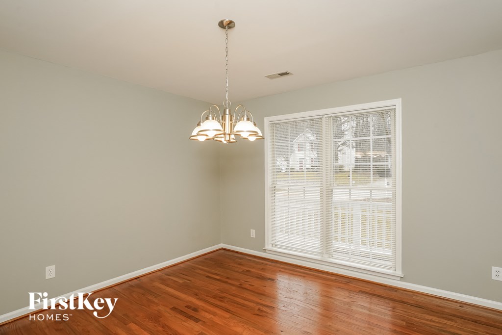 A room with wooden floors and a chandelier hanging from the ceiling.