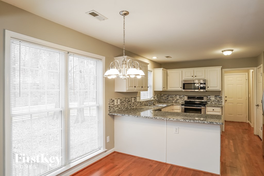 A kitchen with granite countertops and white cabinets.