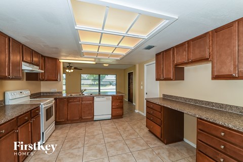 A kitchen with brown cabinets and a Firstkey Homes logo.